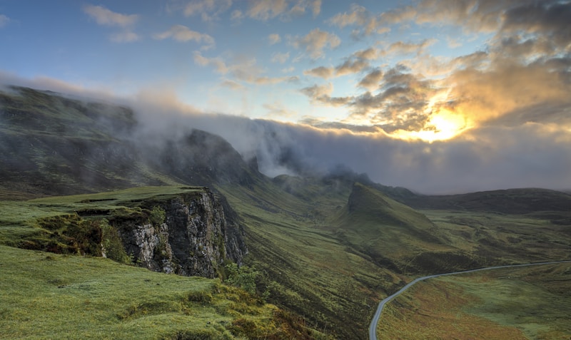 Foggy hills and rolling green meadows at dawn